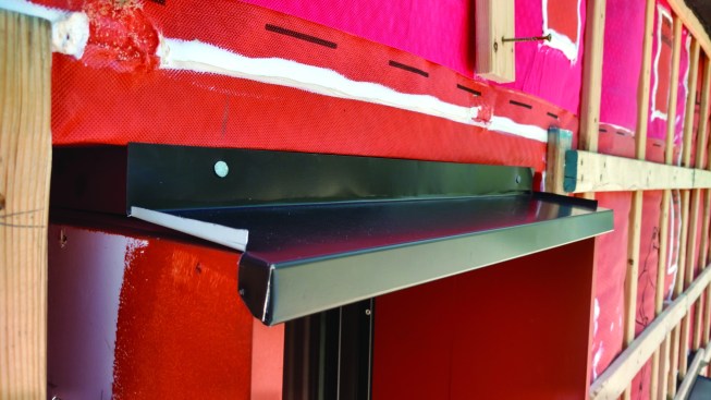 At window heads, the crew applied pre-bent flashing, supplied by the roofing company and made with the same heavy-gauge steel as the roof.