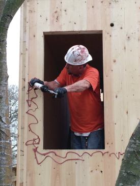 A worker applies a liquid-applied flashing product around a window opening. This material will be spread out to form a continuous film before the windows and insulation are installed. 