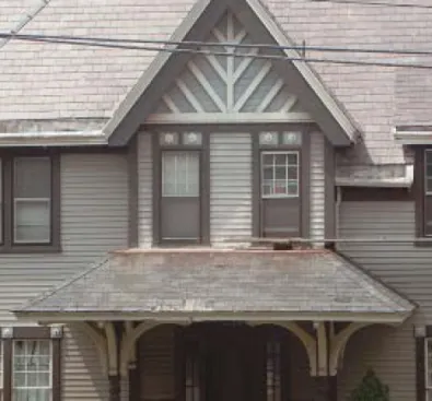 The main roof of this turn-of-the-century Victorian still has most of its original slates, while the asphalt shingles installed on the building’s lower porch roof in mid-century are at the end of their service life.