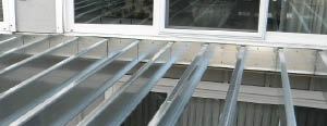 Figure 5. Attach the steel ledger to the house as you would a wood one, with 1/2-inch lag bolts and standard flashing details.