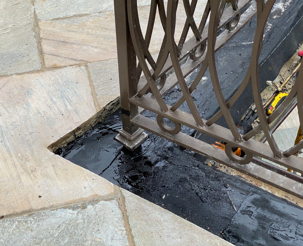 To remedy the problem, the author’s company  waterproofed around the post bases before resetting the edge stone.