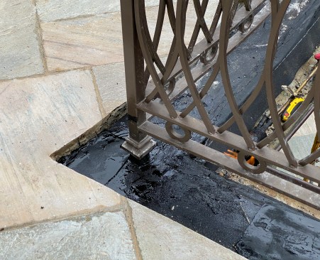 To remedy the problem, the author’s company  waterproofed around the post bases before resetting the edge stone.